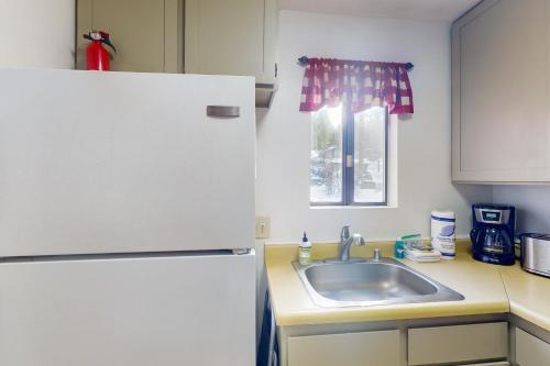 La cuisine est équipée d'un réfrigérateur blanc et d'un évier. dans l'établissement Shaver Haven Condominium, à Shaver Lake