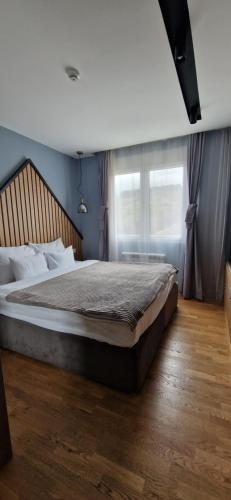 a bedroom with a large bed with a large window at Modern Mountain in Kolašin