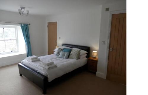 ein Schlafzimmer mit einem Bett mit Kissen und einem Fenster in der Unterkunft The Farmhouse in Durham
