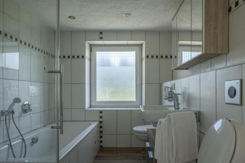 a bathroom with a sink toilet and a window at Wohnung-mit-Panoramablick in Buchenberg