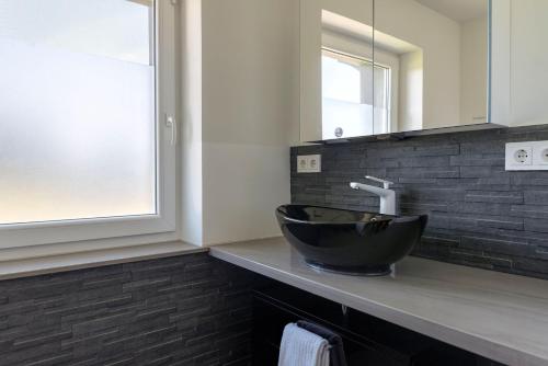 a bathroom with a black sink and a mirror at Wohnung-mit-Panoramablick in Buchenberg