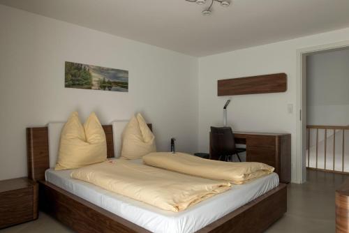 a bedroom with a bed with white sheets and pillows at Wohnung-mit-Panoramablick in Buchenberg