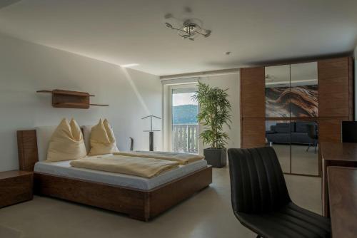 a bedroom with a bed and a chair and a window at Wohnung-mit-Panoramablick in Buchenberg