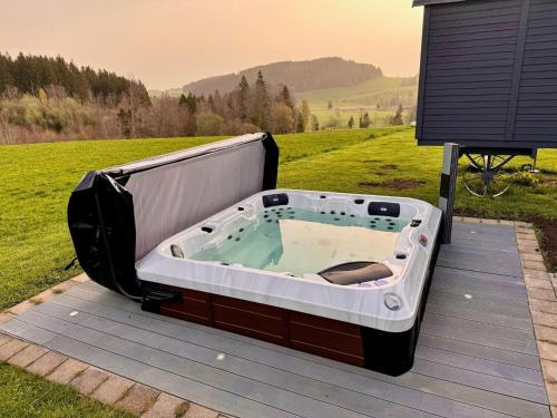 a hot tub sitting on top of a wooden deck at Wohnung-mit-Panoramablick in Buchenberg