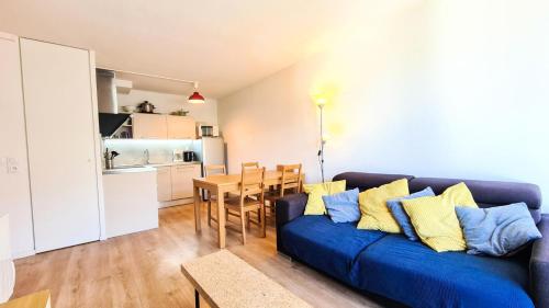 ein Wohnzimmer mit einem blauen Sofa und einem Tisch in der Unterkunft Résidence La Petite Ourse - 3 Pièces pour 6 Personnes 83 in Flaine