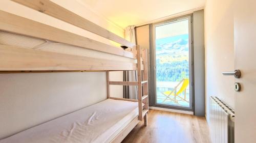 a room with bunk beds and a large window at Résidence La Petite Ourse - 3 Pièces pour 6 Personnes 83 in Flaine