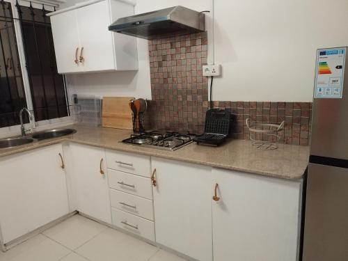 een keuken met witte kasten en een fornuis met oven bij Morsky Vanek Apartment in Flic-en-Flac