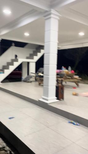 a view of a living room with a staircase in a house at home stay harith & humaira in Lengging