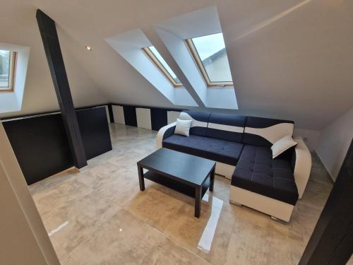 an attic room with a couch and a table at Apartament KNIEJA LUX in Tuchola