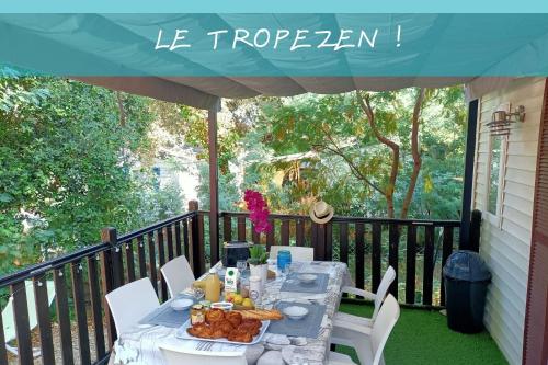 a table with food on a balcony with a blue canopy at Le TropeZen Confort Plus Piscine Chauffée CLIM in Gassin