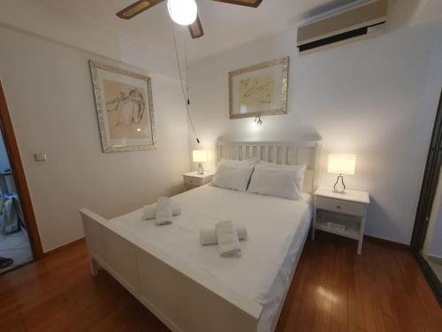 a bedroom with a large white bed with two lamps at Kavouri Seaside 85sqm Apartment 5' from the beach in Athens