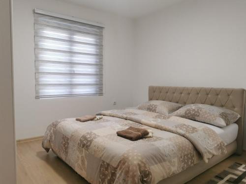 a bedroom with a bed with two pillows and a window at Apartman Mani in Višegrad