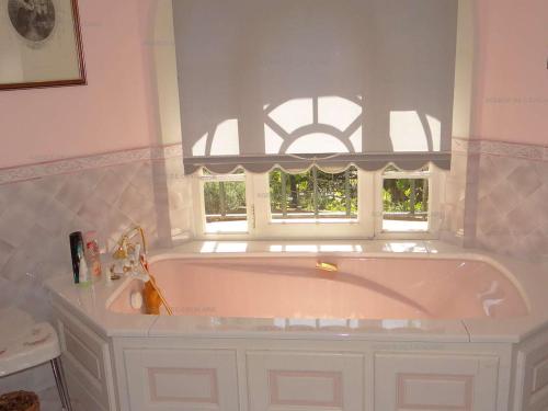 une baignoire dans une salle de bain avec une fenêtre dans l'établissement Villa 4 chambres avec piscine et terrasses - FR-1-100-239, à Cavalaire-sur-Mer