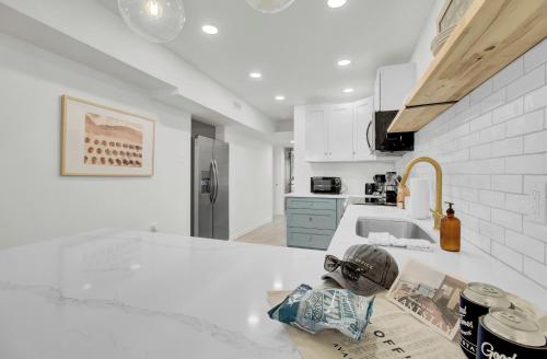 a kitchen with a white counter top and a sink at Live Oak by AvantStay Walk to Folly Beach in Folly Beach