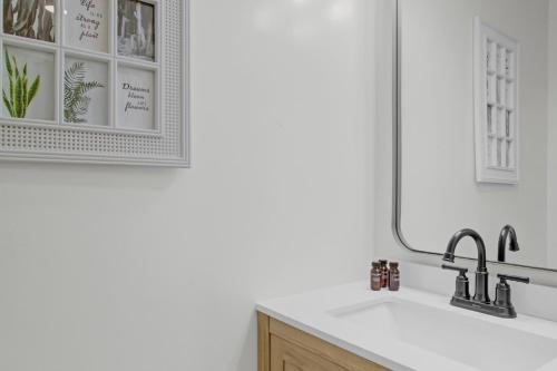 a bathroom with a sink and a mirror at Red Maple by AvantStay Walk to Folly Beach in Folly Beach