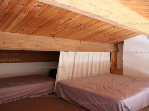 Cette chambre dispose de 2 lits superposés et de plafonds en bois. dans l'établissement Appartement T2 climatisé avec piscine et tennis, 5 couchages - FR-1-100-245, à Cavalaire-sur-Mer