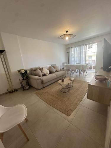 un salon avec un canapé et une table dans l'établissement Bel appartement, sans mauvaises surprises, à Juan-les-Pins