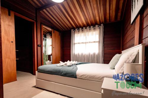 a bedroom with a bed and a window and a television at Casa da Fontinha in Praia da Vitória