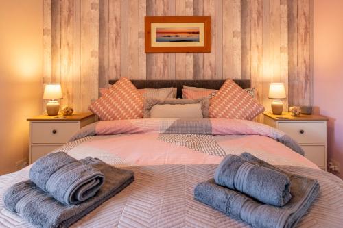 um quarto com uma cama grande com almofadas em Ard Buidhe B&B em Daliburgh