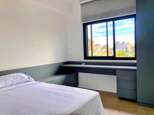 a bedroom with a bed and a large window at 905 A sua casa em Porto Alegre na região central da cidade in Porto Alegre