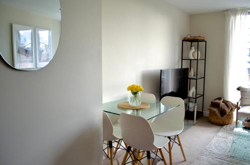 comedor con mesa de cristal y sillas blancas en 1 Bedroom Apartment in Central Manchester, en Mánchester