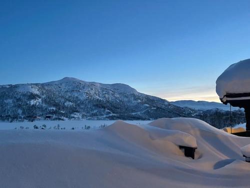 a mound of snow with mountains in the background at Heimro in Torvetjørn
