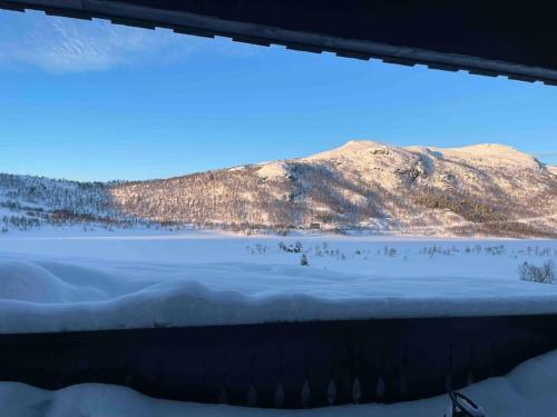 a view of a snow covered mountain and a lake at Heimro in Torvetjørn