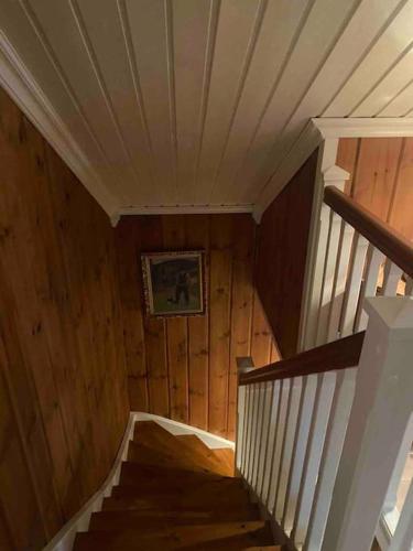 a wooden staircase in a house with a picture on the wall at Heimro in Torvetjørn