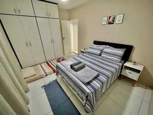 een slaapkamer met een bed met handdoeken erop bij 02 quadras do mar/ Espaçoso/chuveirão externo in Vitória