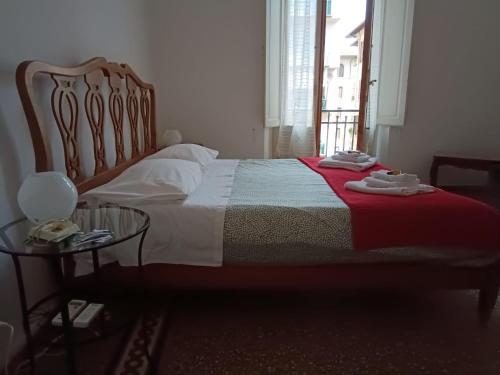 Schlafzimmer mit einem Bett mit einer roten Decke und einem Tisch in der Unterkunft Casa Genny Costa in Florenz