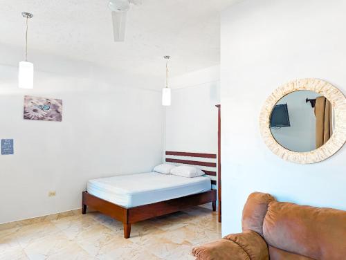 Zimmer mit einem Bett, einem Spiegel und einem Sofa in der Unterkunft Casa Anastacia in San Ignacio