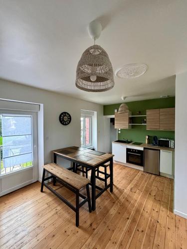 - une cuisine avec une table et un banc dans une pièce dans l'établissement Gîte de la petite tour, à Pontorson