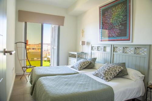 a bedroom with two beds and a large window at Sea View apartment 2B in Poris de Abona
