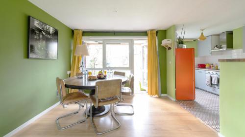 a dining room with green walls and a table and chairs at 25 Percent OFF Monthly Stays, Business Family Sleeps 4, Best for Long Term Stays in London