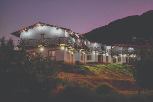 a building with lights on the side of it at night at Nápoles Ecolodge Hotel in Anta