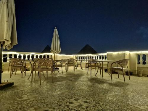 a group of chairs and umbrellas on a patio at night at Pyramid stars inn in Cairo