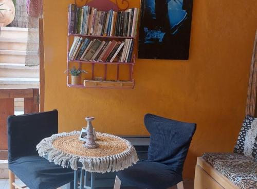 a table with two chairs and a book shelf with books at Hanna's Place - Great Location in Eilat