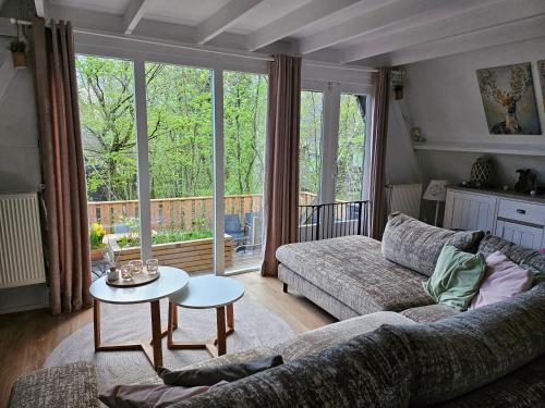 ein Wohnzimmer mit einem Sofa und einem Tisch in der Unterkunft Het Hertenbos chalet 136 in Durbuy