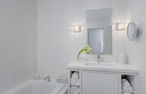a white bathroom with a tub and a sink at Huntley Santa Monica Beach in Los Angeles