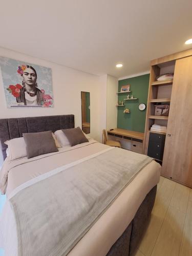 Un dormitorio con una cama grande y una pared verde en Estudio en edificio con piscina climatizada, en Bogotá