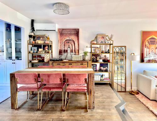 a kitchen with a wooden table and pink chairs at Beautiful Luxury Shared Home in Montreal in Montreal