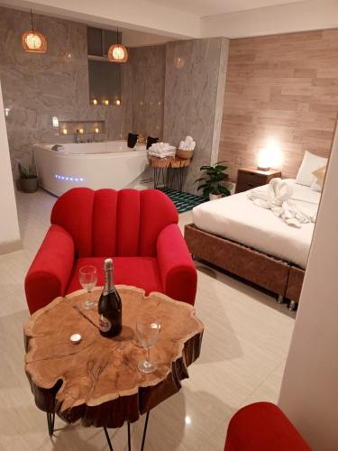 a living room with a red couch and a table with wine glasses at HOTEL CUSCO PERU in Cusco