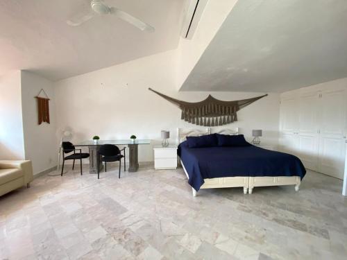a bedroom with a bed and a table with chairs at CASA BLANCA in Cancún