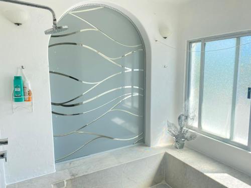 a bathroom with a shower with a large window at CASA BLANCA in Cancún