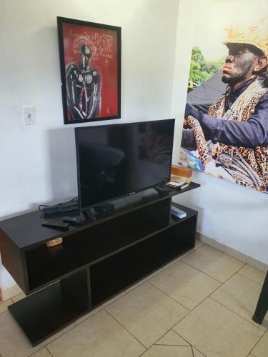 a living room with a television and a picture of a man at Casa de Campo, frente a la playa Skybluebyguanche in Colón