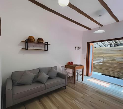 a living room with a couch and a table at Vila Saíra, chalé Laranja, 50m da praia in Ilhabela