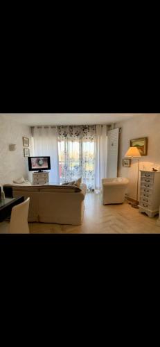 een woonkamer met een bank en een tafel bij Cosy unoverlooked apartment with swimming pool in Mandelieu-la-Napoule