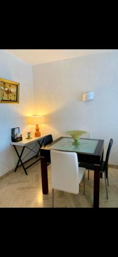 d'une salle à manger avec une table et une chaise blanche. dans l'établissement Cosy unoverlooked apartment with swimming pool, à Mandelieu-la-Napoule
