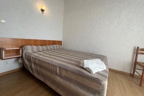 Cette chambre comprend un petit lit et une chaise. dans l'établissement Spacious apartment with lovely terrace, à Port-la-Nouvelle