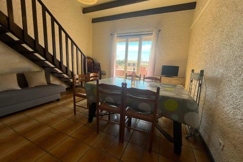 une salle à manger avec une table et quelques chaises dans l'établissement Spacious apartment with lovely terrace, à Port-la-Nouvelle